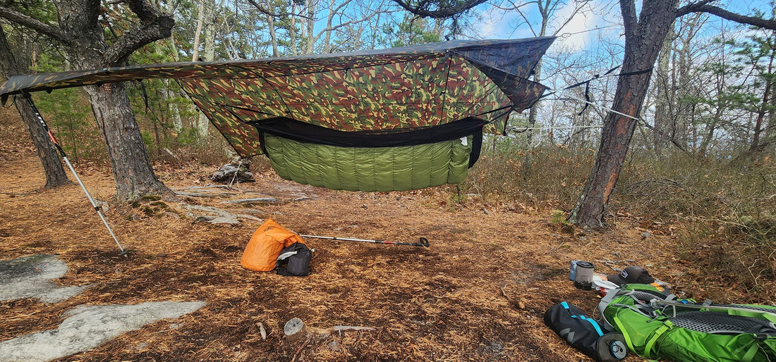 A full hammock camping kit at a ridge campsite — Jacks R Better tarp pitched over a hammock and down underquilt