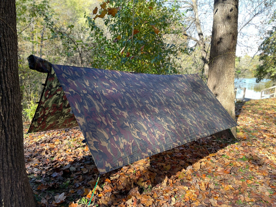 Jacks R Better camo hammock tarp pitched in an A-frame lean-to beside a lake in autumn