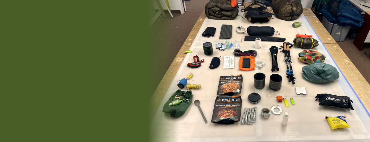 Ultralight backpacking kit laid out on the Jacks R Better workshop table — JRB down quilts plus trail gear from the makers we use.