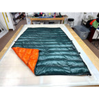 Custom ultralight backpacking quilt with a Forest Green shell and Burnt Orange lining, foot corner folded back