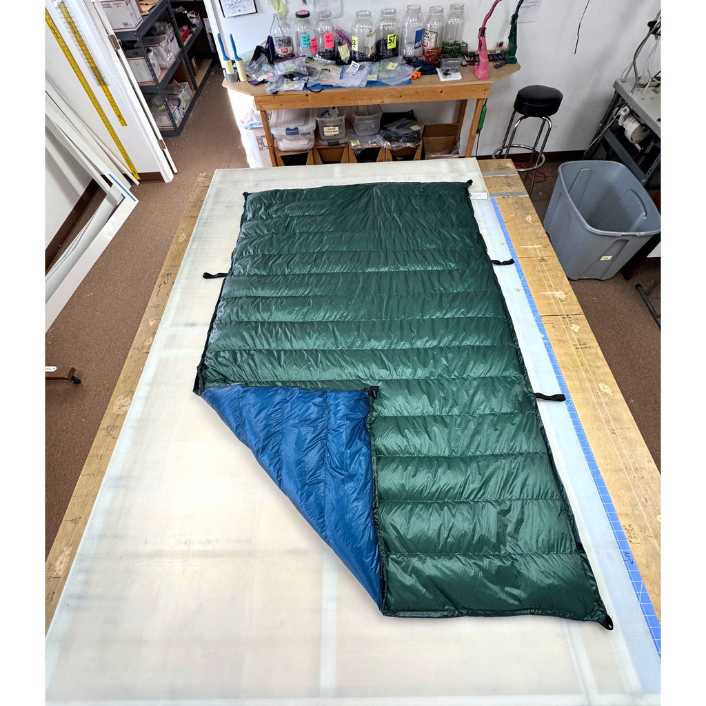 Custom ultralight backpacking quilt with a Forest Green shell and Moroccan Blue lining, folded to show both colors