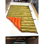 Custom ultralight backpacking quilt with a Moss Green shell and Burnt Orange lining, corner folded back