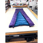 Custom ultralight backpacking quilt with a Purple shell and Moroccan Blue lining, folded to show both colors