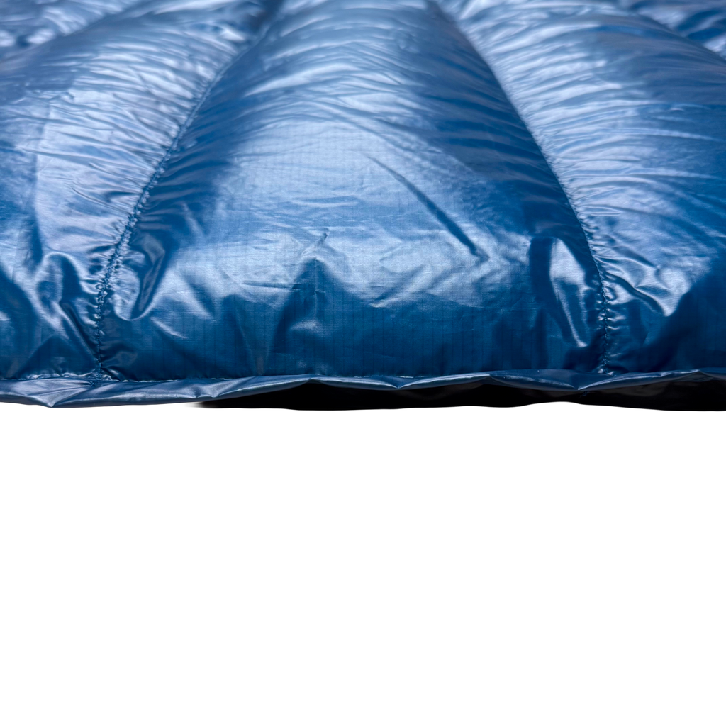 Close-up detail of Jacks R Better Hudson River Ultralight 20 degree backpacking quilt showing Moroccan Blue Argon 67 ripstop shell and baffle loft