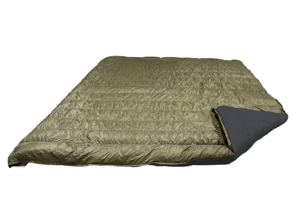 Jacks R Better Overland 20°F overlanding and RV camping quilt laid flat, dark olive shell with the corner turned back to show the black lining